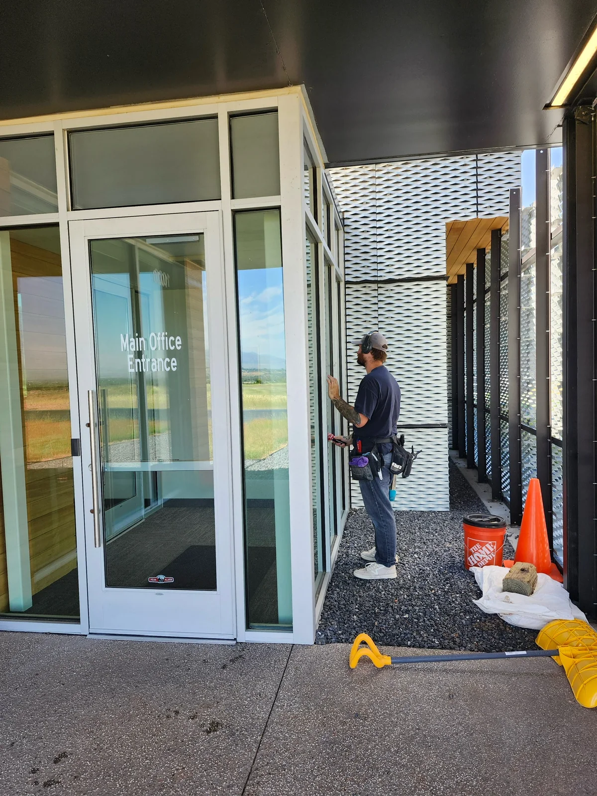 Clearly Clean technician cleaning commercial entrance glass