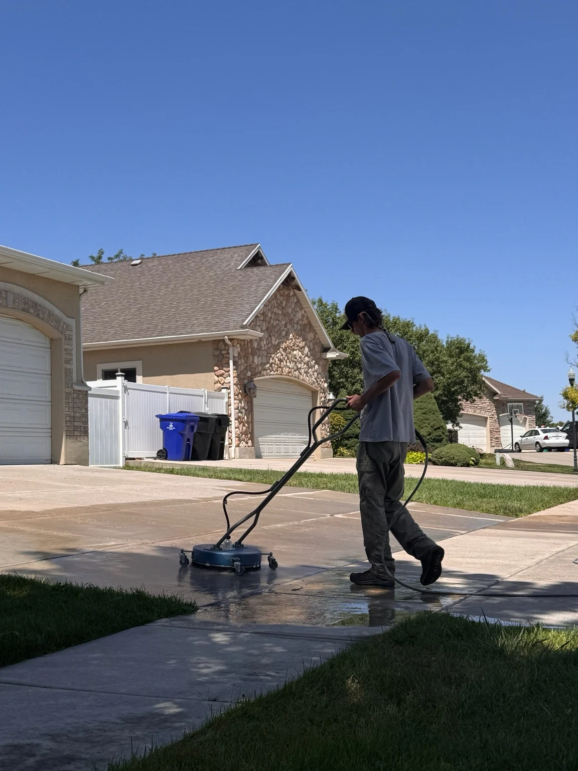 Clearly Clean pressure washing a residential driveway with a surface cleaner