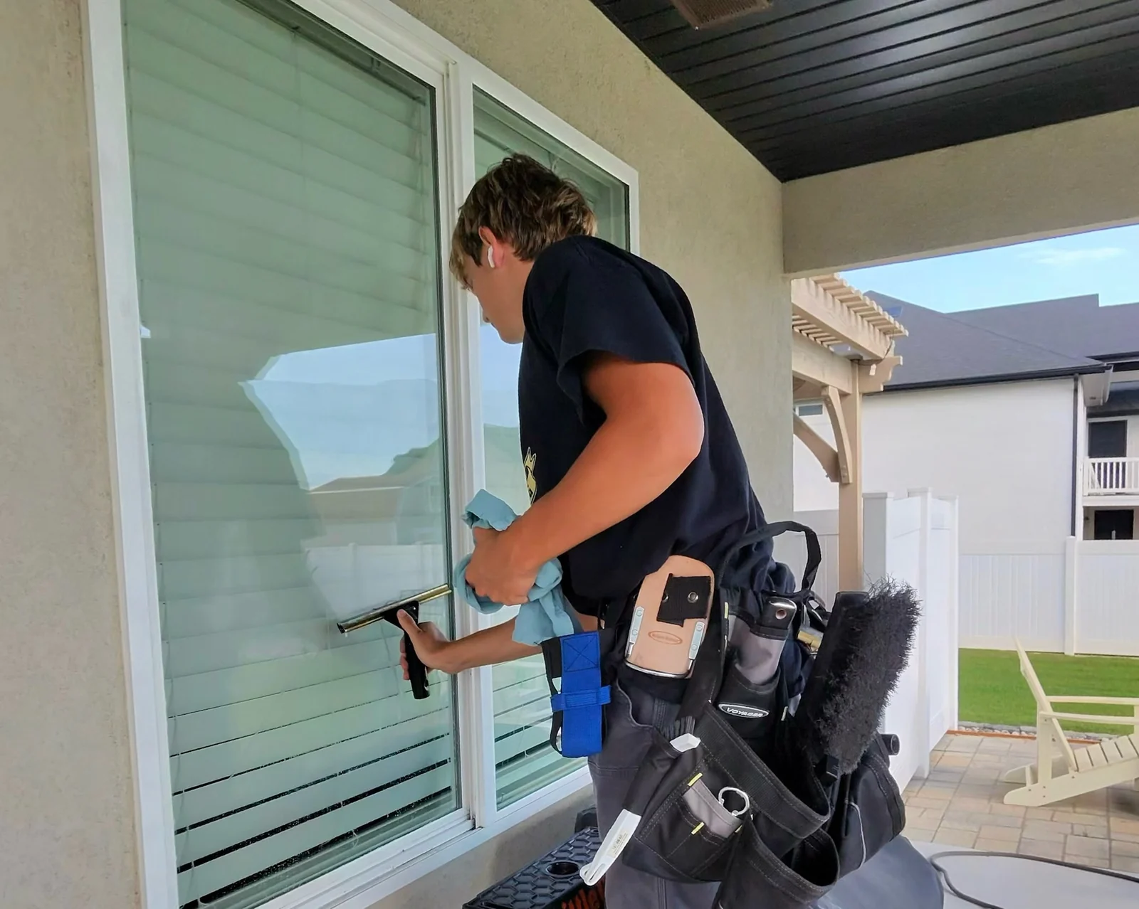 Clearly Clean technician squeegee cleaning a residential window